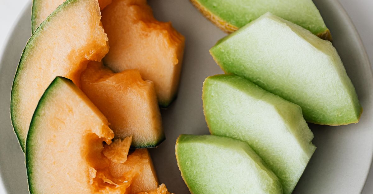 Vue de dessus d'une assiette avec des tranches de melon cantaloup orange et de melon miel vert coupées en quartiers.