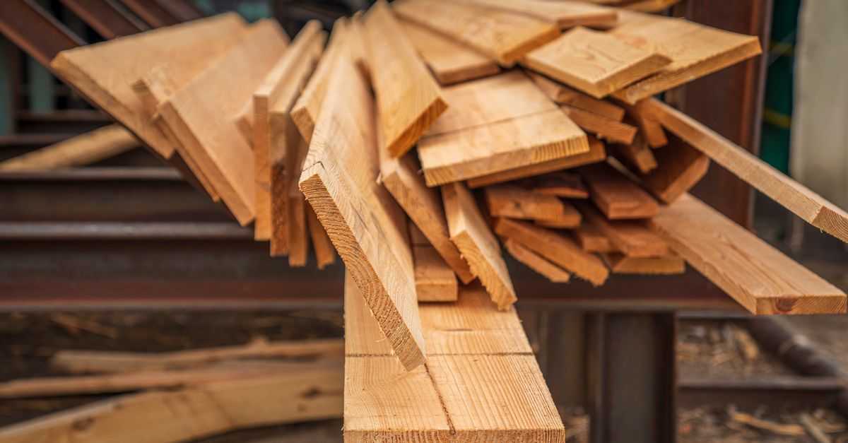 Un tas de planches de bois démontées et empilées en désordre sur un chantier de rénovation.