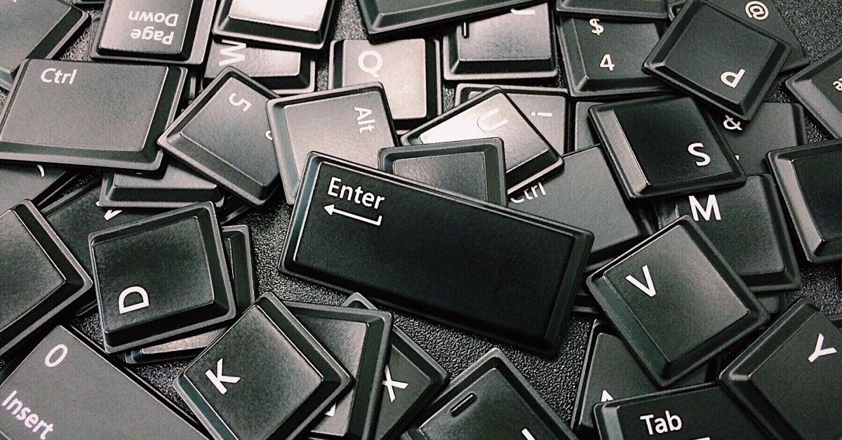 Un tas de touches de clavier détachées et empilées en désordre, avec la touche Entrée au premier plan.