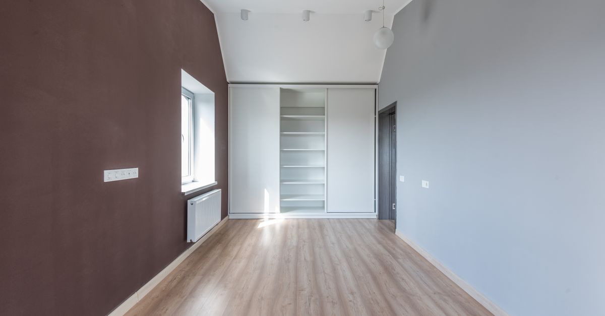 Chambre étroite avec un placard blanc intégré à portes coulissantes et étagères ouvertes au centre du mur du fond.