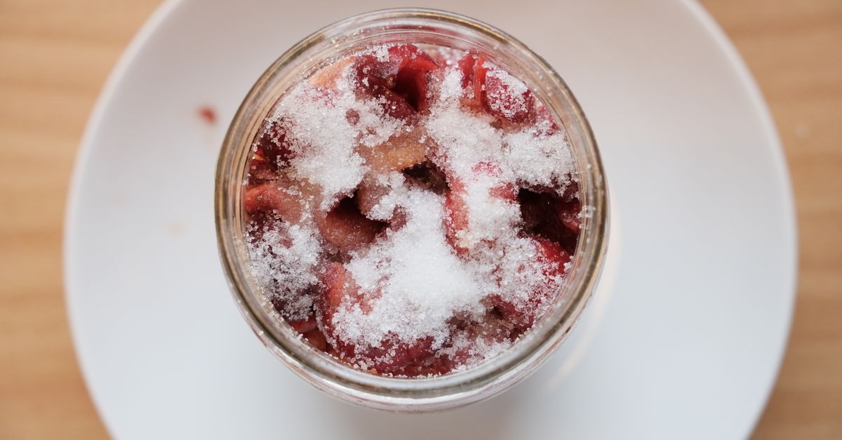 Pot en verre vu de dessus contenant des morceaux de betteraves rouges recouverts de givre, posé sur une assiette blanche.